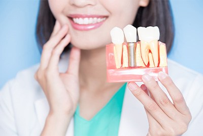 Dentist in Plain City showing a dental implant model